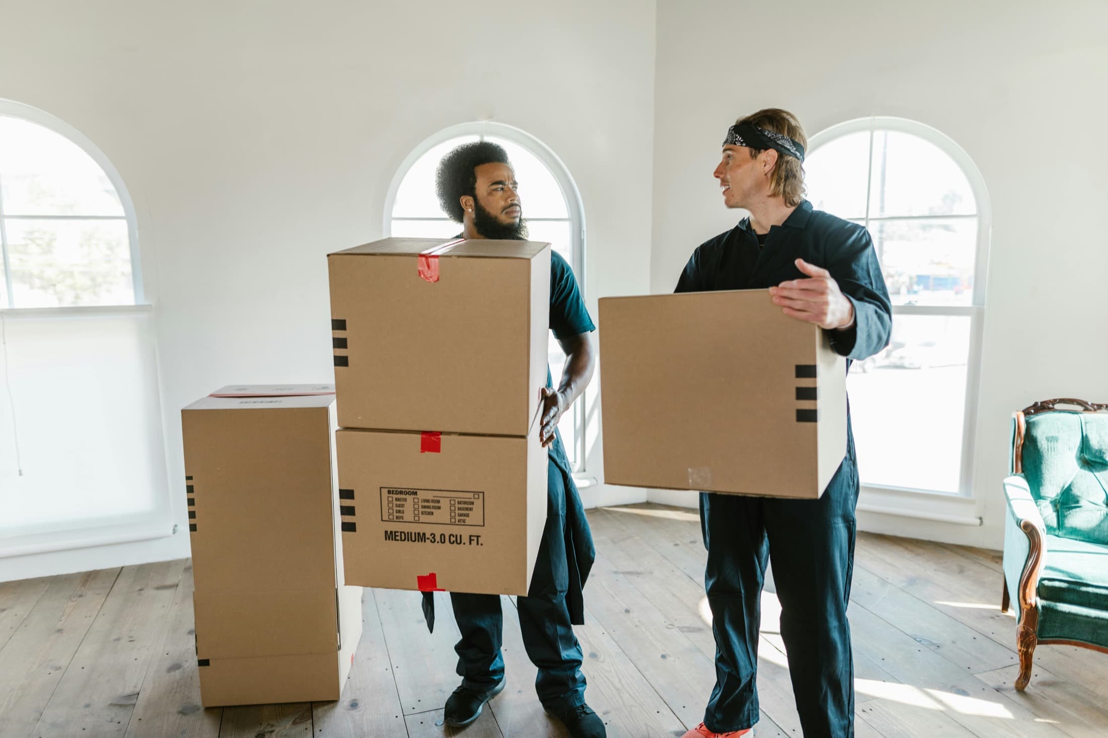Men carrying moving boxes into an apartment